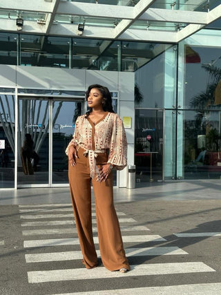 MIYA SET est l’image de la femme bureaucrate moderne. Il s’agit d’un ensemble pantalon et chemise qui allie crêpe léger fluide et crêpe lourde pour le pantalon. Le plissé de la chemise est un pli serré qui ne grossi pas, mais épouse parfaitement votre morphologie. Un pantalon uni avec des détails en motif sur la ceinture et les poches ( avant et arrière ) associé à un chemisier sophistiqué aux motifs vintage (bogolan marron et indigo bleu ) rehausse votre élégance. Idéale pour les morphologies V , X