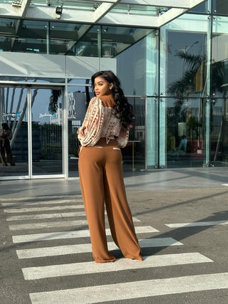 MIYA SET est l’image de la femme bureaucrate moderne. Il s’agit d’un ensemble pantalon et chemise qui allie crêpe léger fluide et crêpe lourde pour le pantalon. Le plissé de la chemise est un pli serré qui ne grossi pas, mais épouse parfaitement votre morphologie. Un pantalon uni avec des détails en motif sur la ceinture et les poches ( avant et arrière ) associé à un chemisier sophistiqué aux motifs vintage (bogolan marron et indigo bleu ) rehausse votre élégance. Idéale pour les morphologies V , X